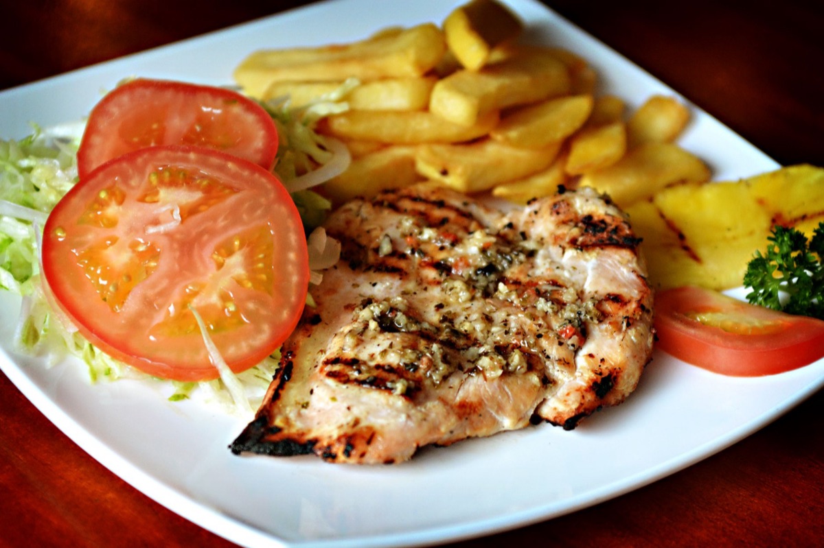 Filet de poulet grillé avec gras et fibres musculaires visibles