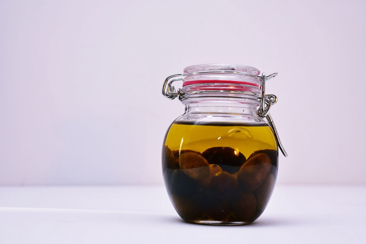 olive oil jar with fresh vegetables