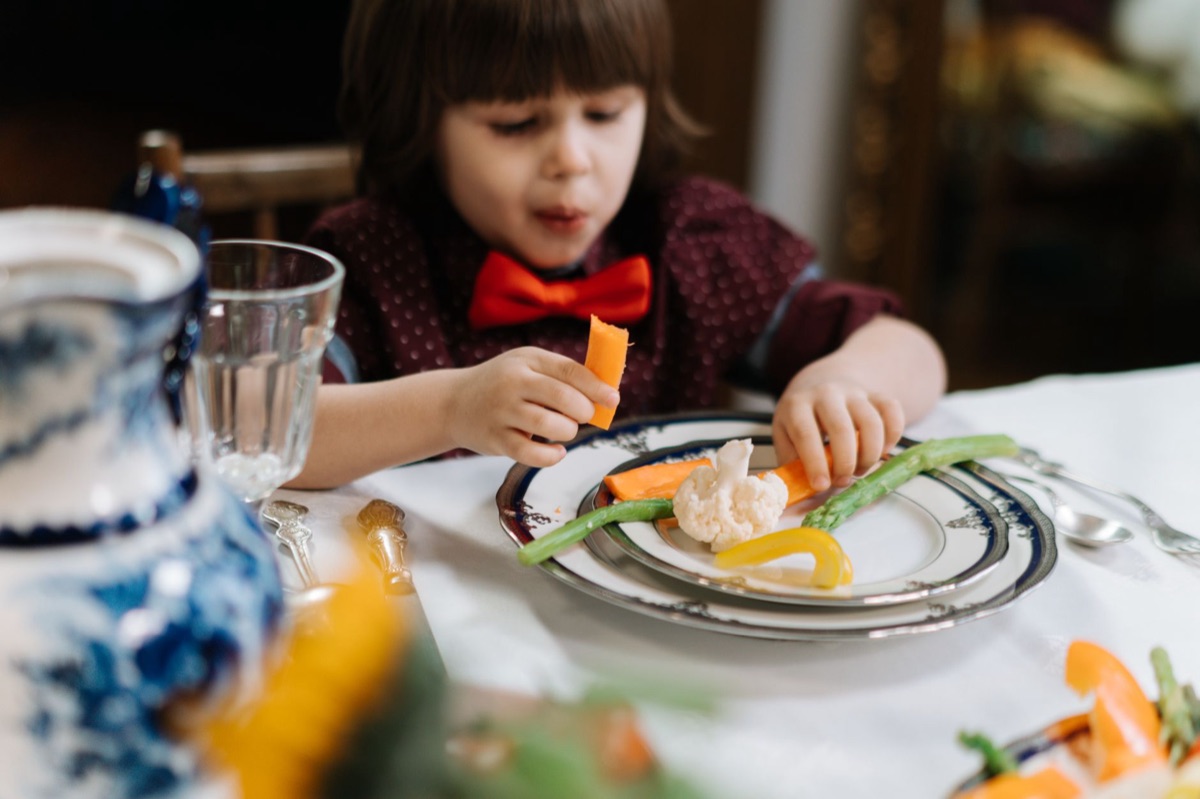 Child eating a balanced meal with fresh fruits and vegetables