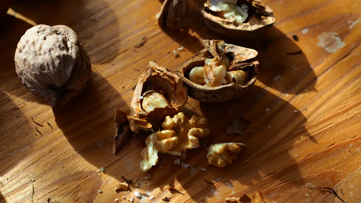 Cracked walnuts on a wooden table in natural sunlight. Perfect for healthy food and rustic themes.
